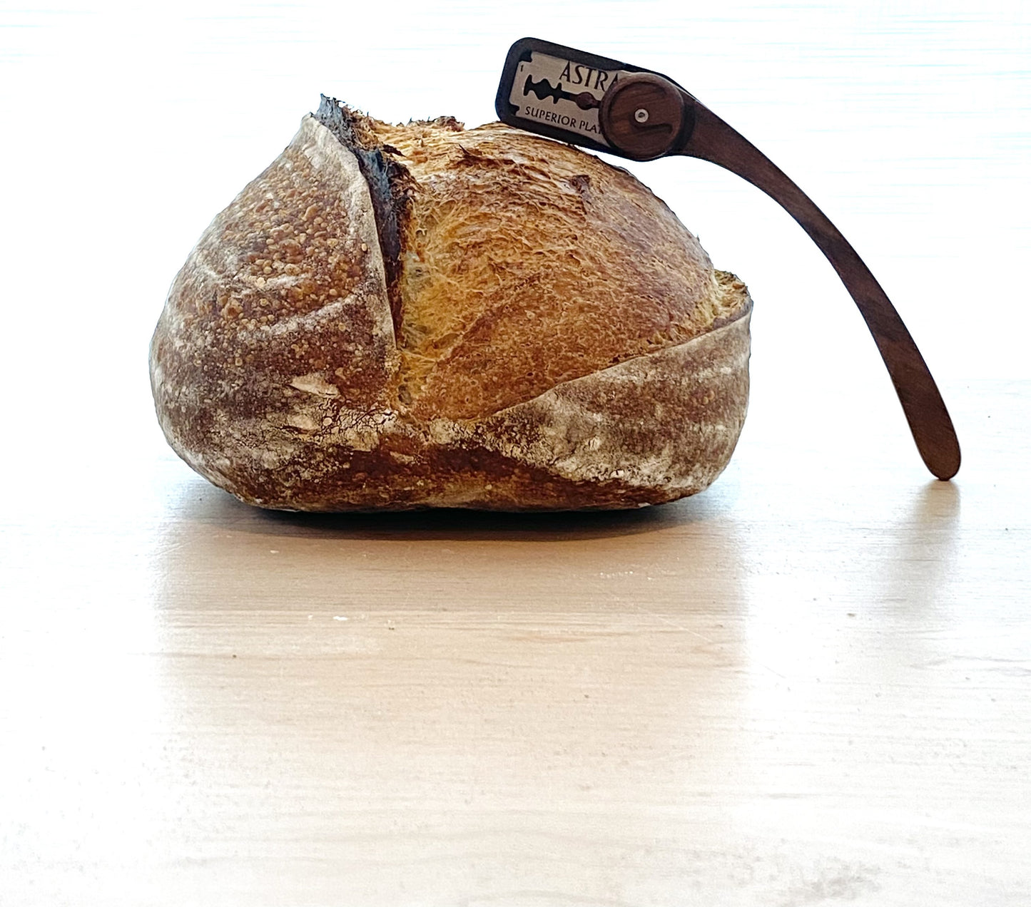 A sourdough boule with a clean expansion cut, scored with a Wire Monkey Goose lame, baked by Abigail Yueh